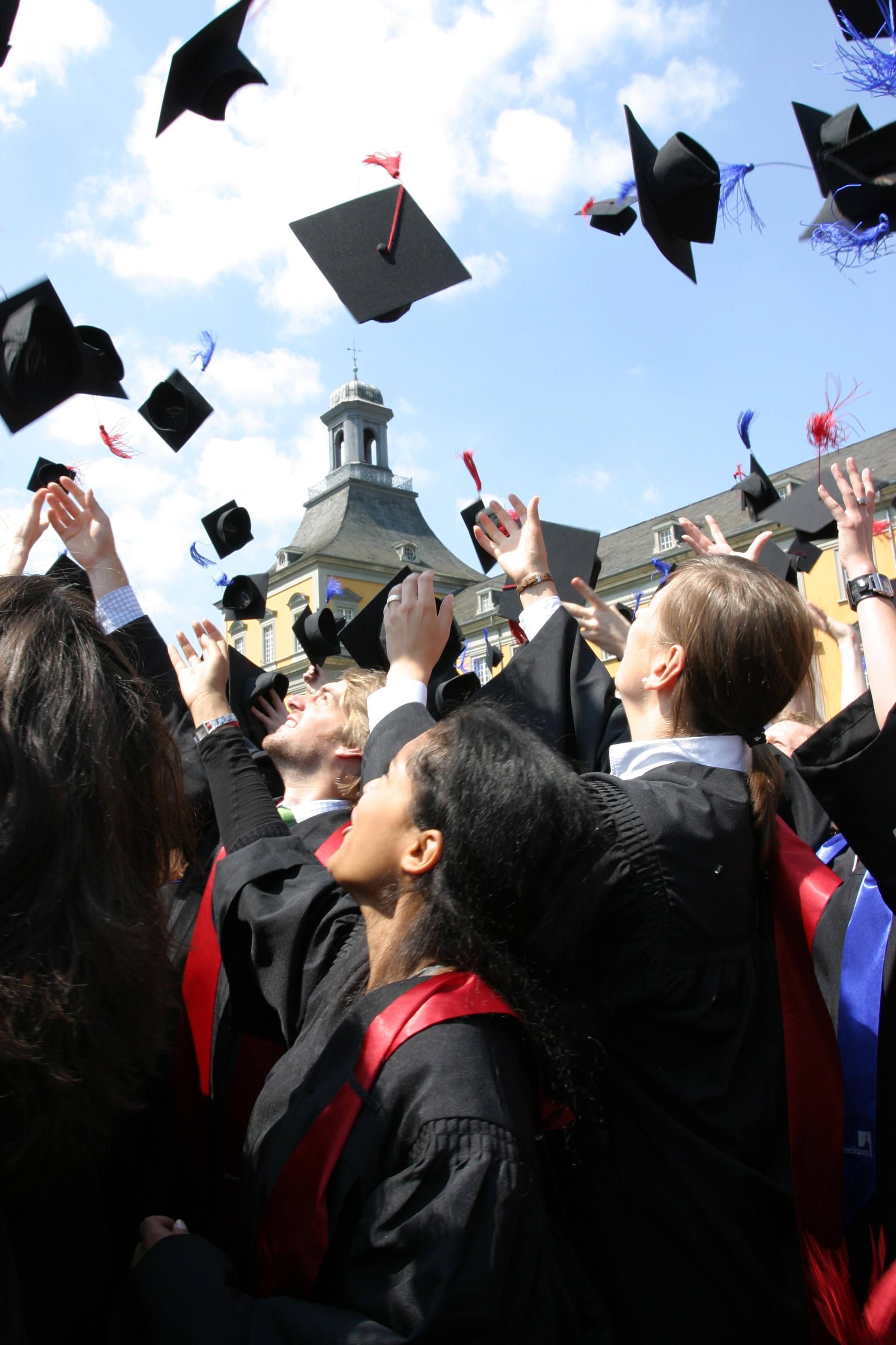 Absolventen werfen Doktorhüte in die Luft