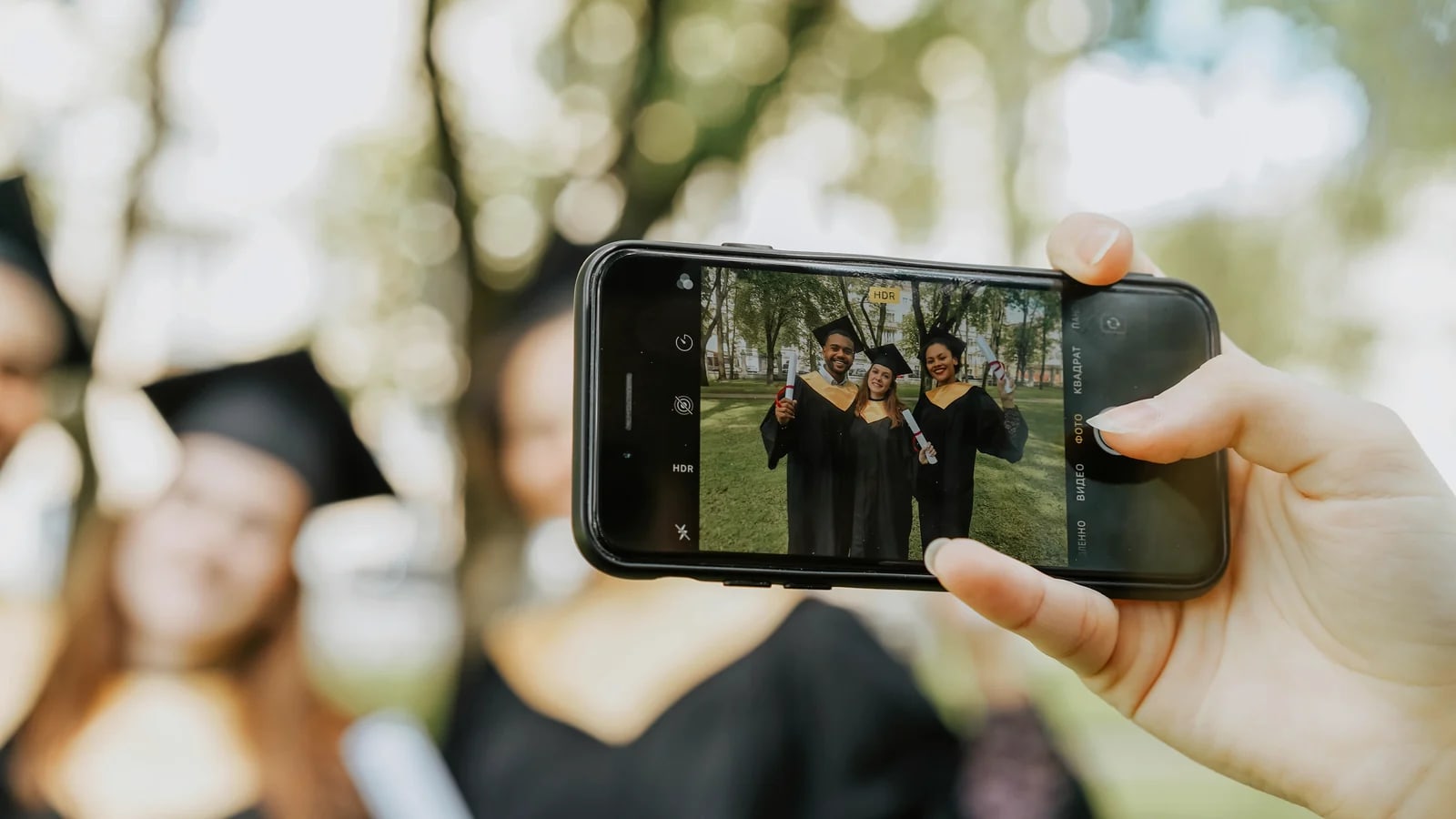 Abschluss-Moment wird mit dem Smartphone festgehalten – Erinnerungen fürs Memorybook