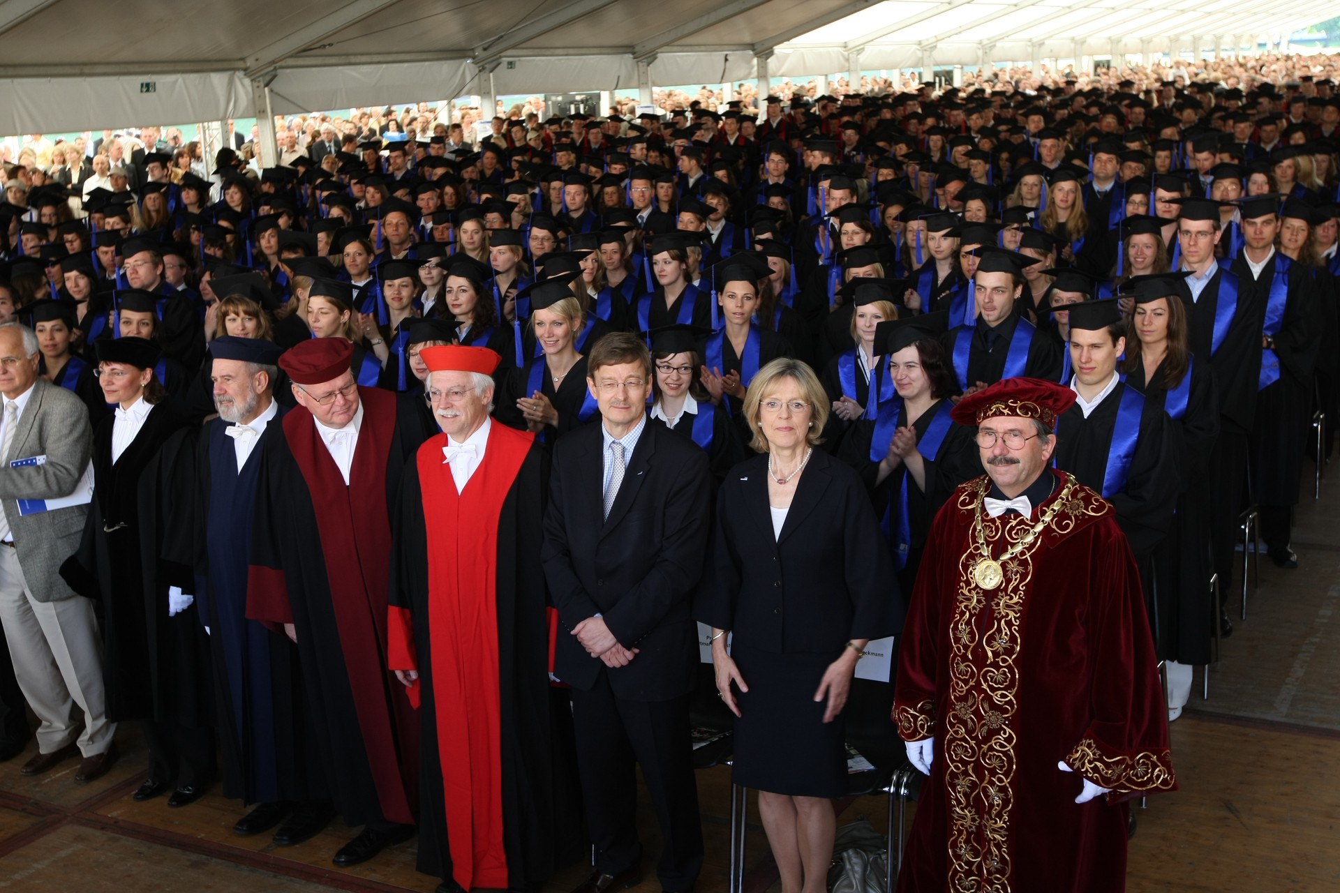 Große Graduierungszeremonie – Professoren und Absolventen in akademischer Kleidung